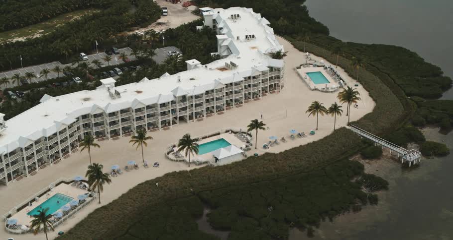 A resort near the coast with trees and swimming pools