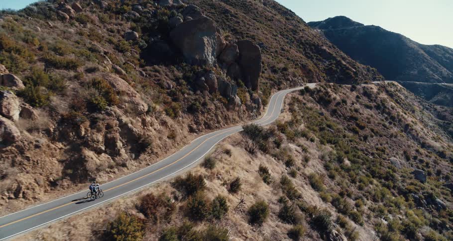 Two people biking on a rural road