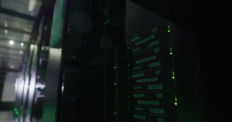 Green lights shine from behind grill on servers in data center