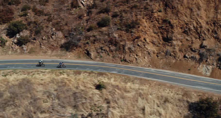 Aerial view of two bicycles traveling on a winding mountain road