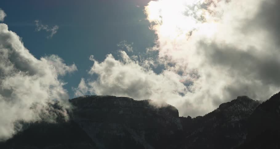 Mountains high in the sky among the clouds on a sunny day