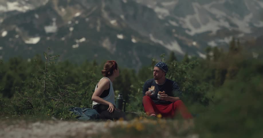 A man and a woman are having a picnic in the mountains