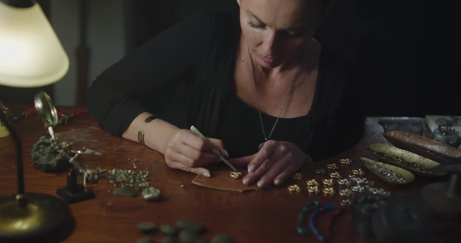 A jeweler puts gems in to a ring setting