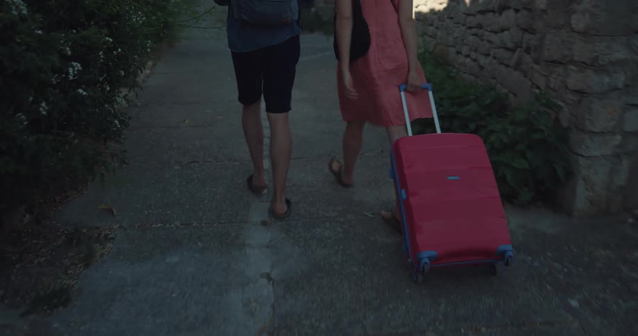 A man and woman stroll down a sidewalk in a rural village