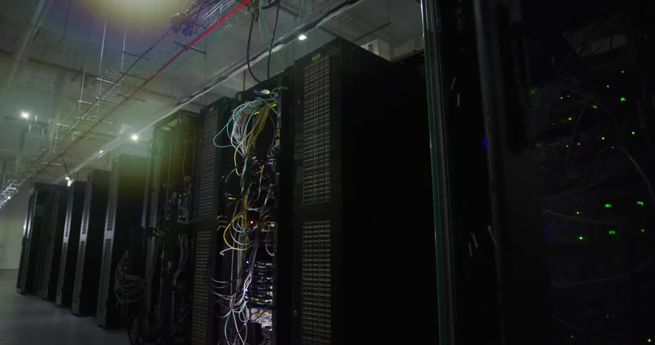 Wires and lights occupy servers in data center with pale ceilings and floors