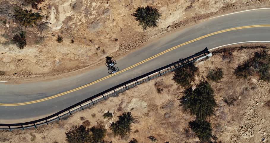 Aerial view of two bicycles traveling on a winding mountain road