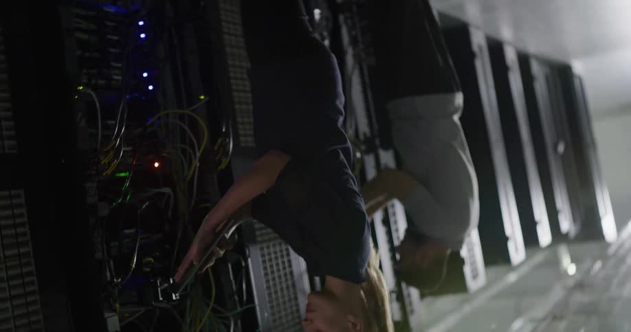 It technicians examine data servers one using a tablet