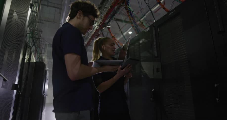 A man and woman use a laptop to troubleshoot equipment on a server