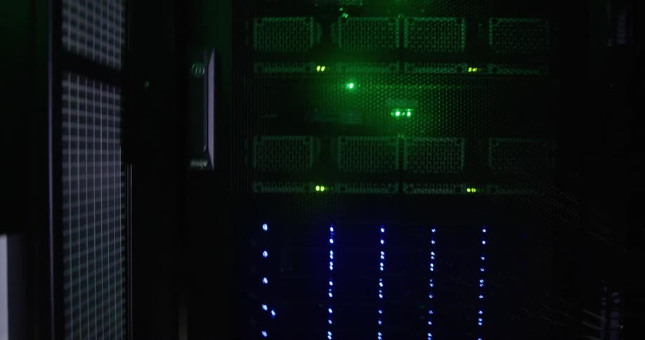 Blue and green lights shine among grills of computer servers