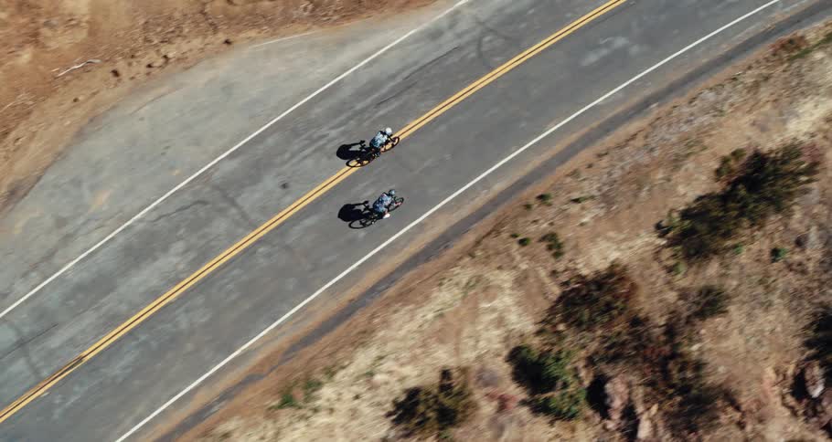 Two cyclists are peddling up a mountain road