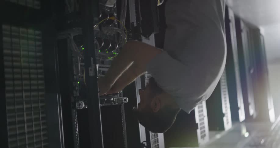 A man in a computer room works on a server