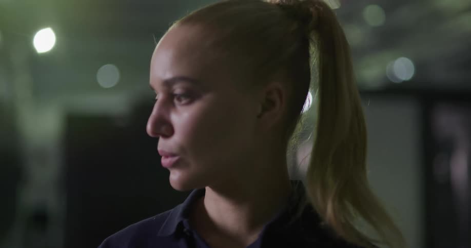 A woman is looking up and down at something and turns her head