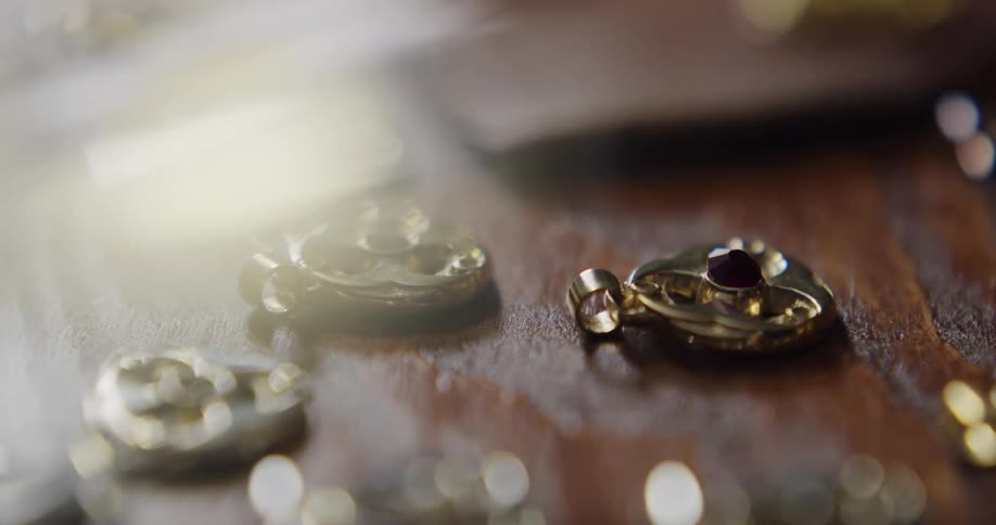 A small stone is getting set into a gold piece of jewelry