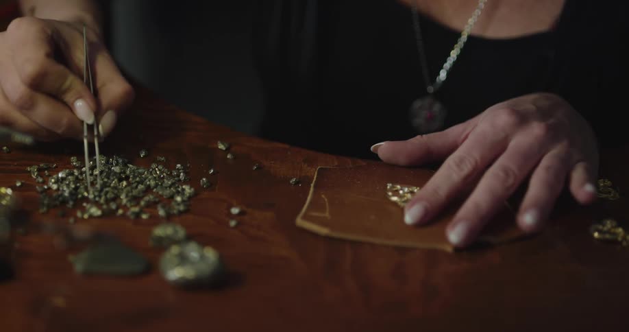 A woman is searching through bead pieces