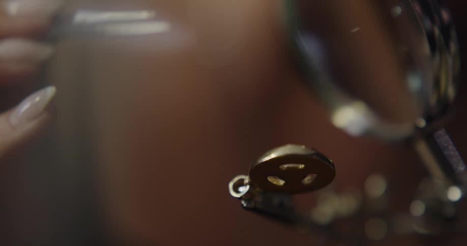 A jewelry maker is using a tweezers to work