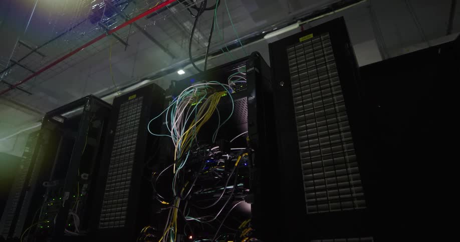 A data server has its case open and numerous wires are hanging out of it
