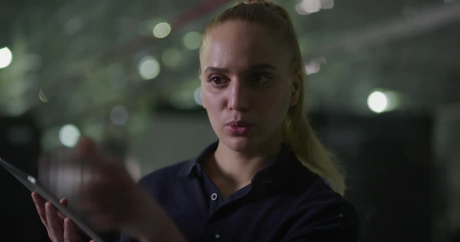 Blonde woman holding tablet makes gestures swiping selecting and touching in mid air