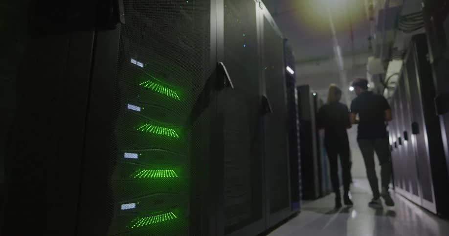 Two people walk down the server room