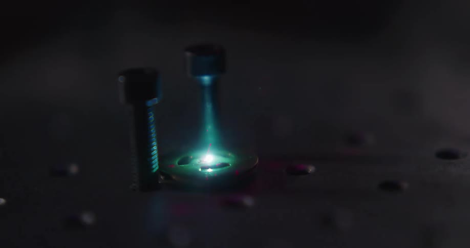 A laser is pointing at some electrical components in a dark room