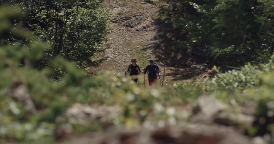 Two people are hiking towards the hill