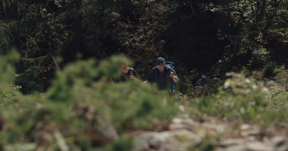 A man and woman talk as they hike up a hill