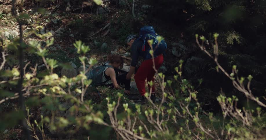 A man and woman hiking and the woman fell and hurt her leg