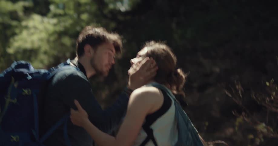 Man and woman kissing on a hiking trail after stumbling