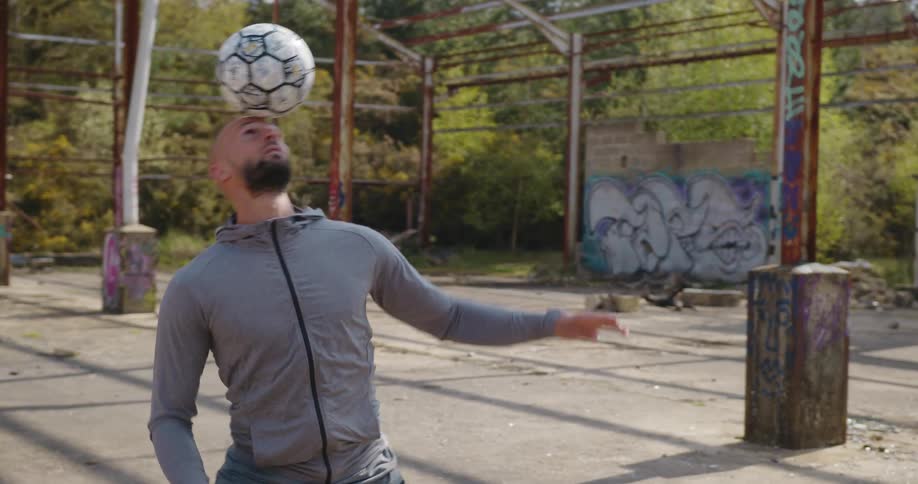A man balances a soccer ball on his face doing ball tricks