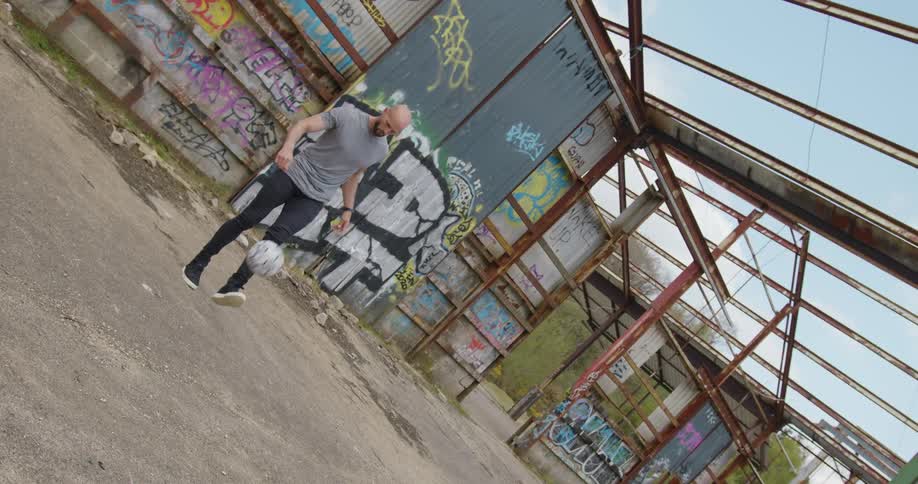 A man kicking a soccer ball outdoors