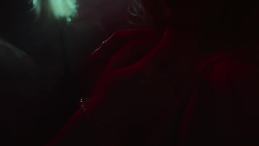 Two people holding hands intimately in the dark