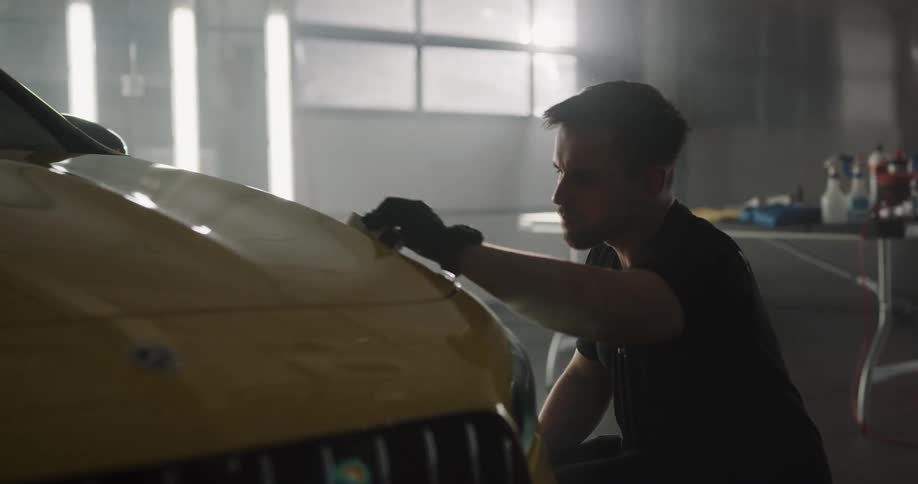 An employe cleaning and detailing a car