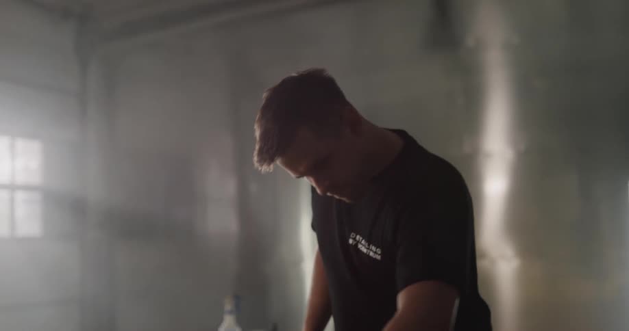 A man is in a garage and cleaning a car