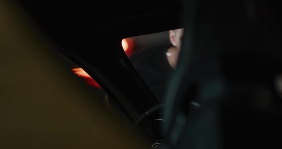 Man wipes the windshield of a vehicle with a cloth