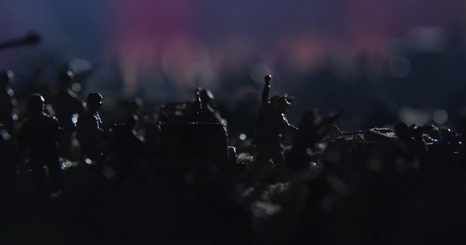 Smoke and sparks flow across surface of shadowy diorama of soldier miniatures