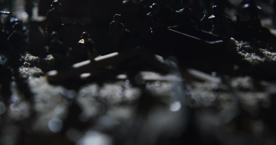 The toy soldiers are lined up in the dark