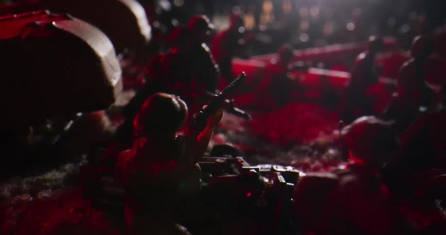 A diorama of small military toys on a battlefield wielding guns while a light flashes above them