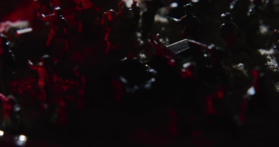 A number of plastic figurines of soldiers are placed into a pretend battlefield