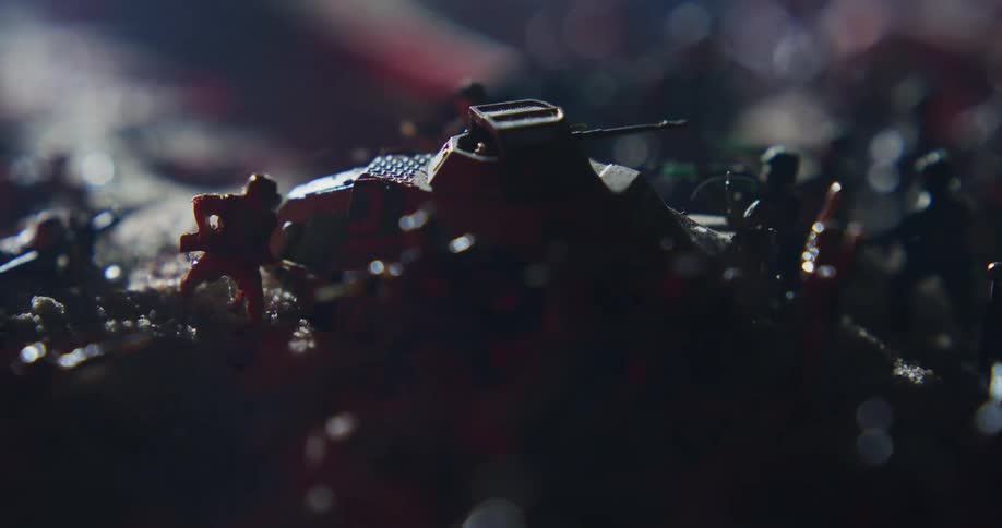Light moves over shadowed diorama of miniature tanks and soldiers