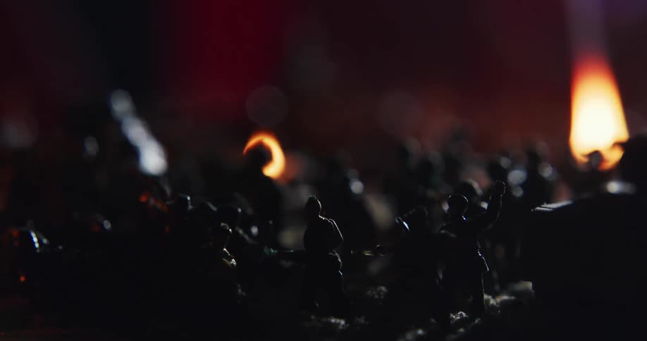 Flame set on diorama battlefield of miniature soldiers and vehicles flares up releasing a cloud of smoke