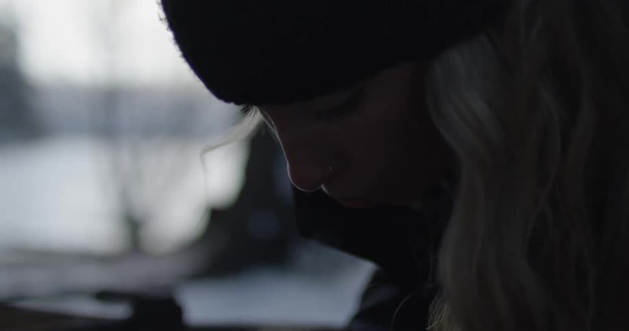 A woman exhales and blows out steam outside on a frigid day