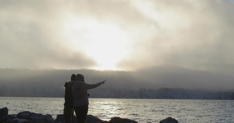 Two people are posing for a photograph together at sunset