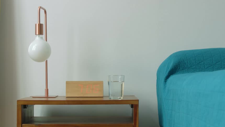 A view of a table with a lamp and glass on it