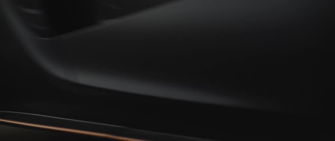 A sports car speeds down a road during the day