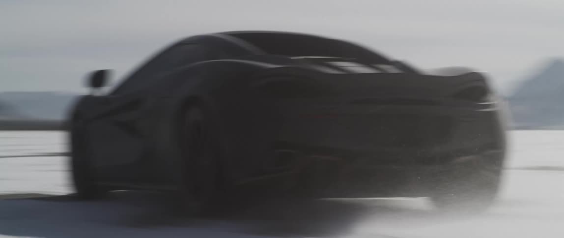 A sports car travels offroad through a snowy field in the countryside during the day