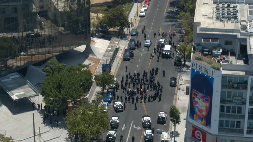 Police gather in a city street as bystander look on