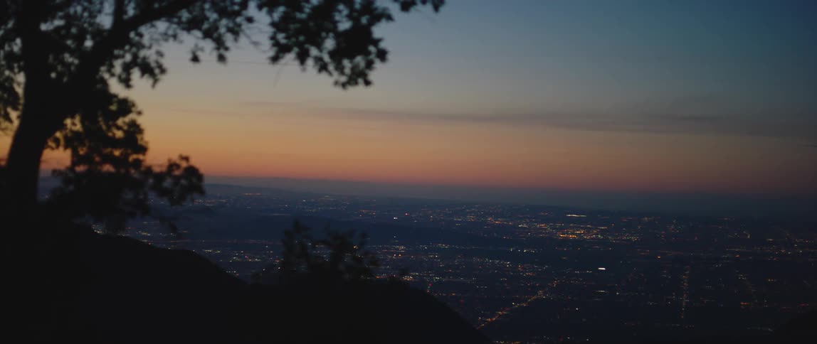 The sun is setting over the city ahead
