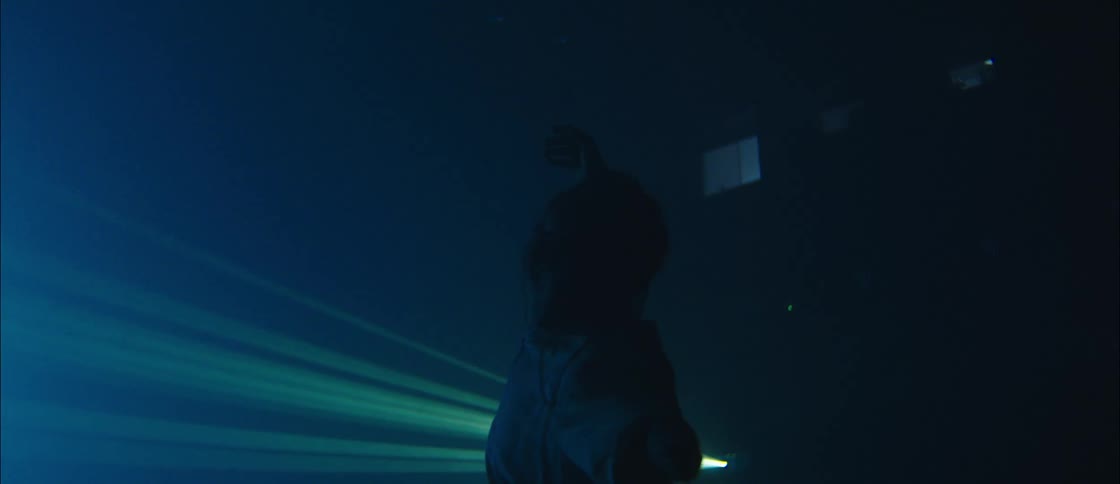 Male dancer moves and poses in foggy room near laser lights
