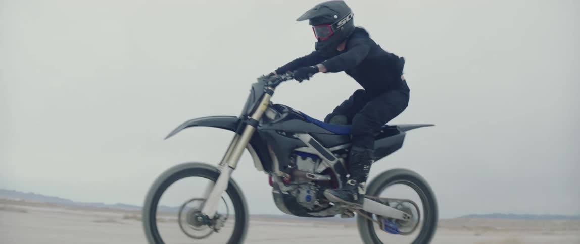 A man races through the sand on a dirt bike