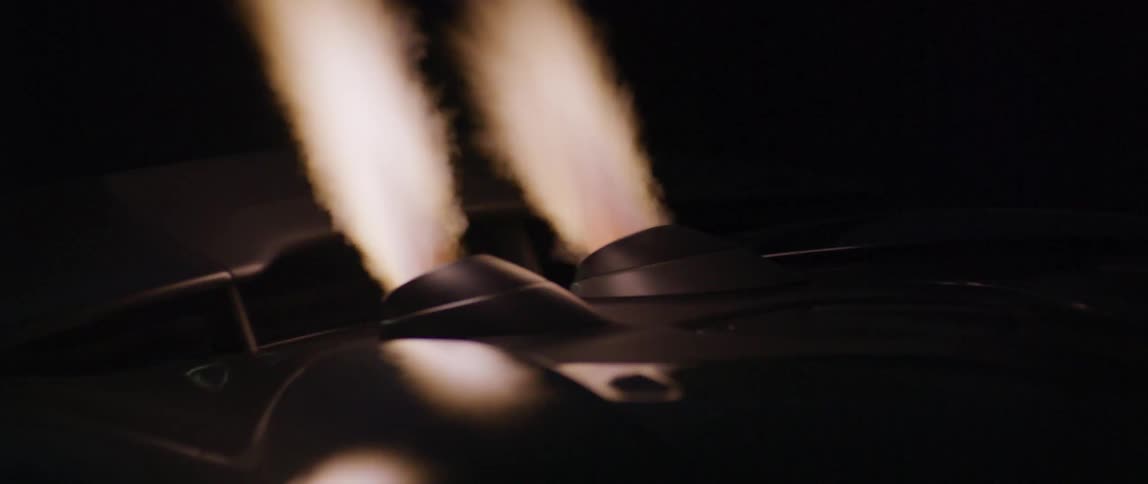 A view of flames out of the exhaust of a car at night