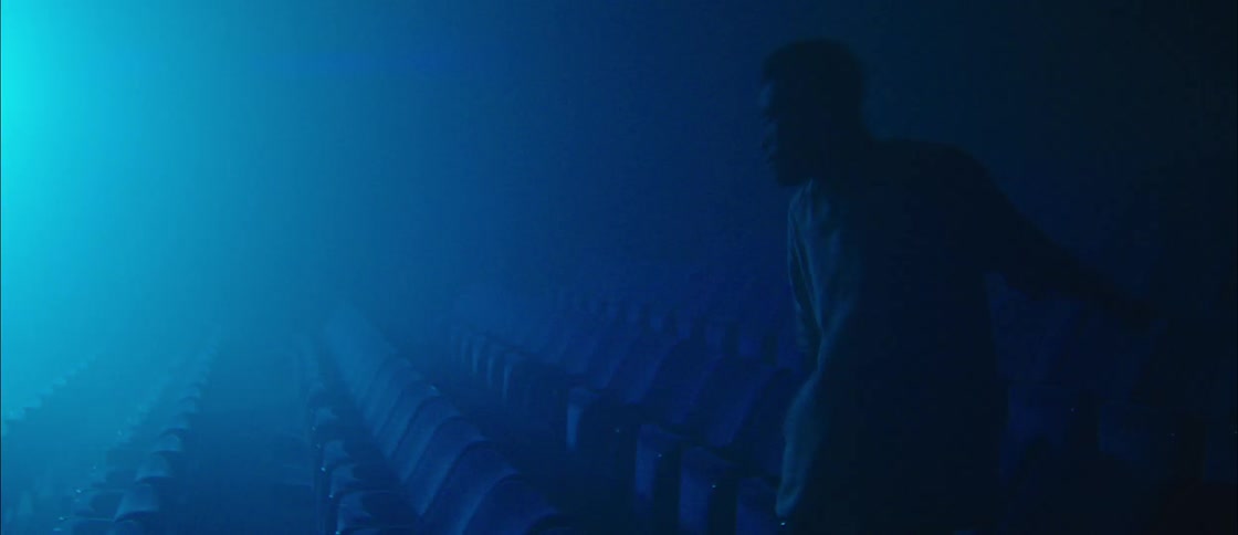 Man wearing headphones dances in an auditorium